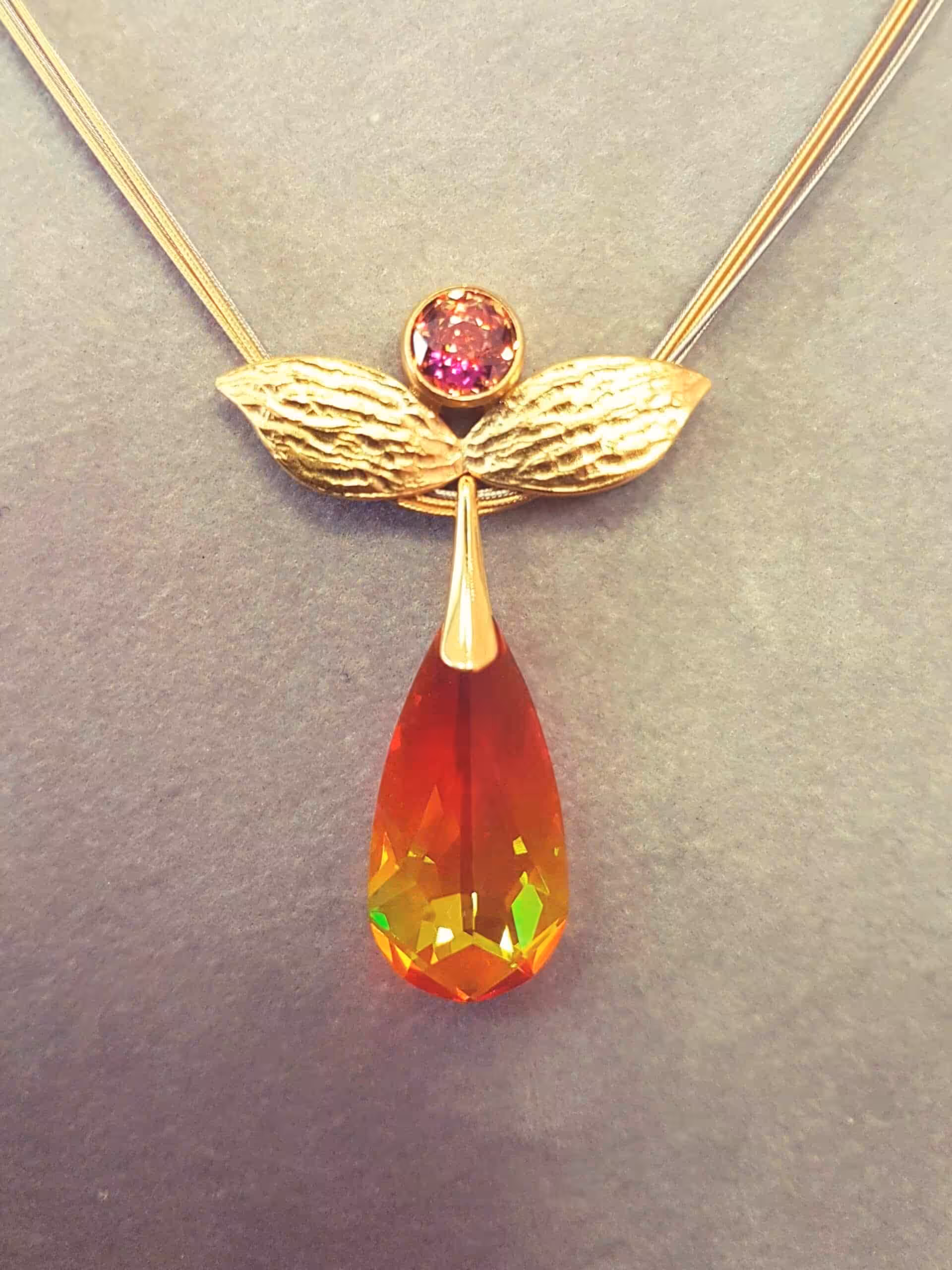 Schmuckanhänger mit Edelstein und Flügel-Design.