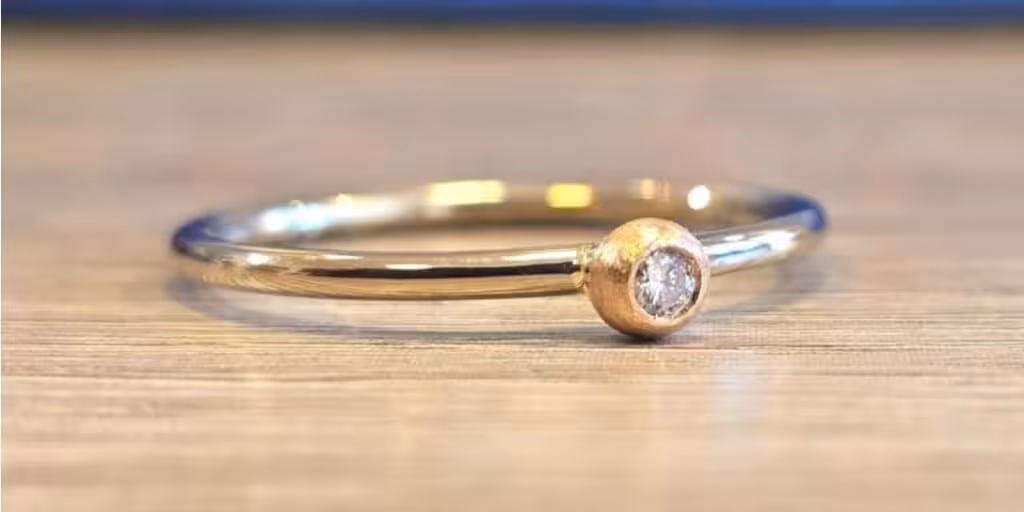 Trauringe selber schmieden: Personalisierte Eheringe aus Gold mit Diamant.