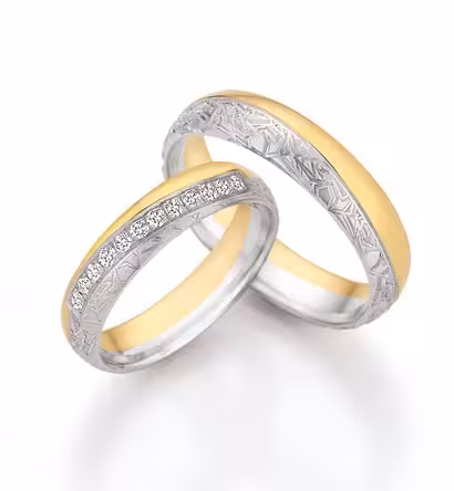 Person schmiedet individuelle Trauringe aus Gold und Diamanten, handgefertigt bei Trolese.