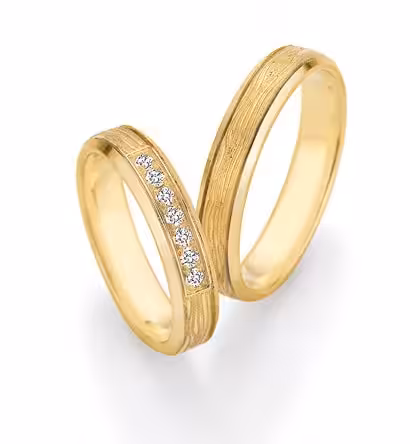 Zwei goldene Trauringe, einer mit Diamanten, beim Selber-Schmieden.