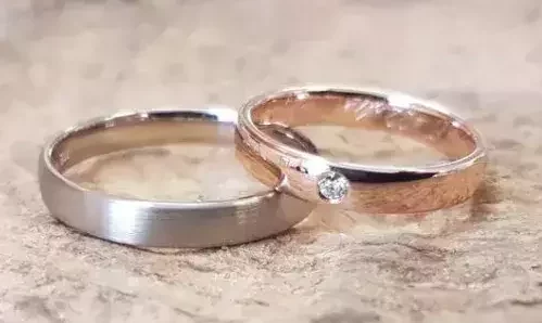 Trauringe aus Weißgold und Roségold, von einem Hochzeitspaar selbst geschmiedet, ein Ring mit Brillant.