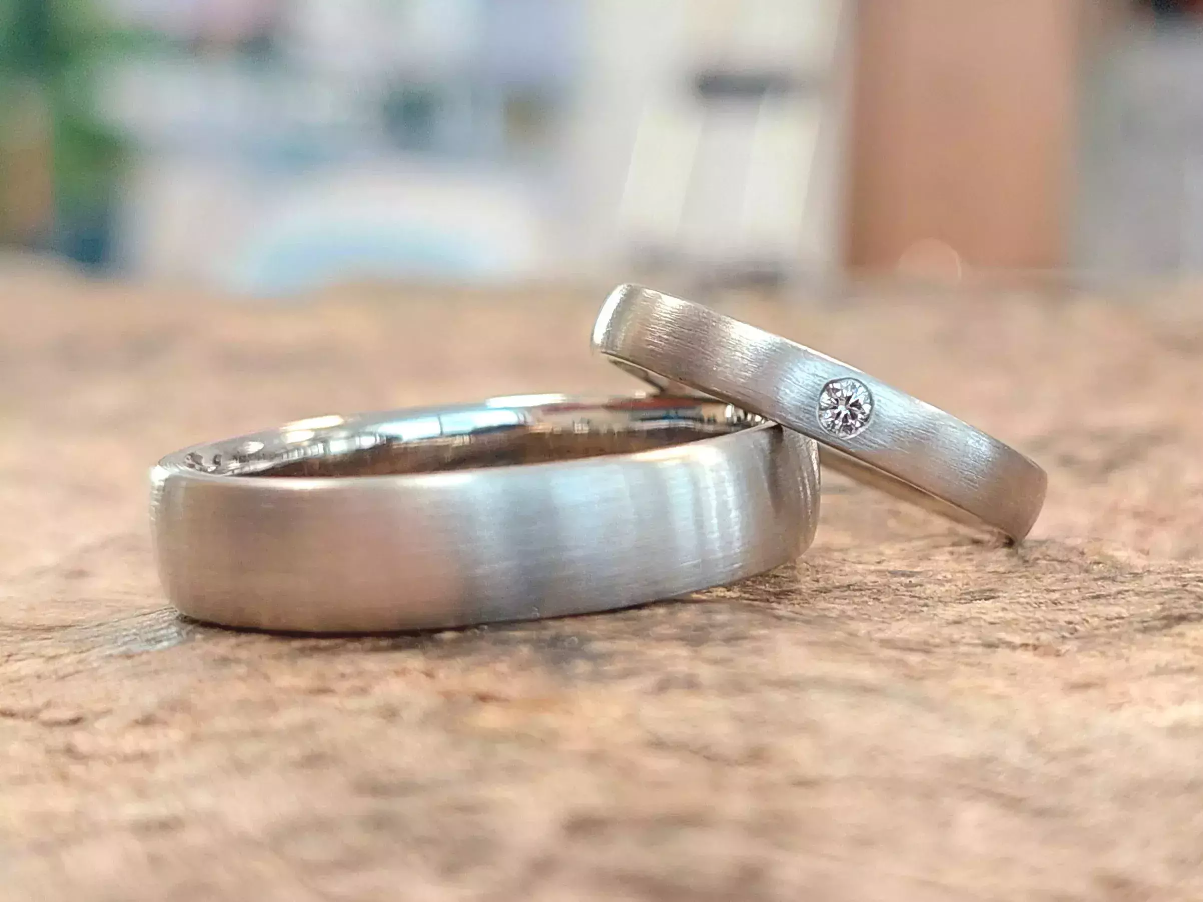 Selbst geschmiedete Trauringe mit matter Oberfläche und eingefasstem Diamant
