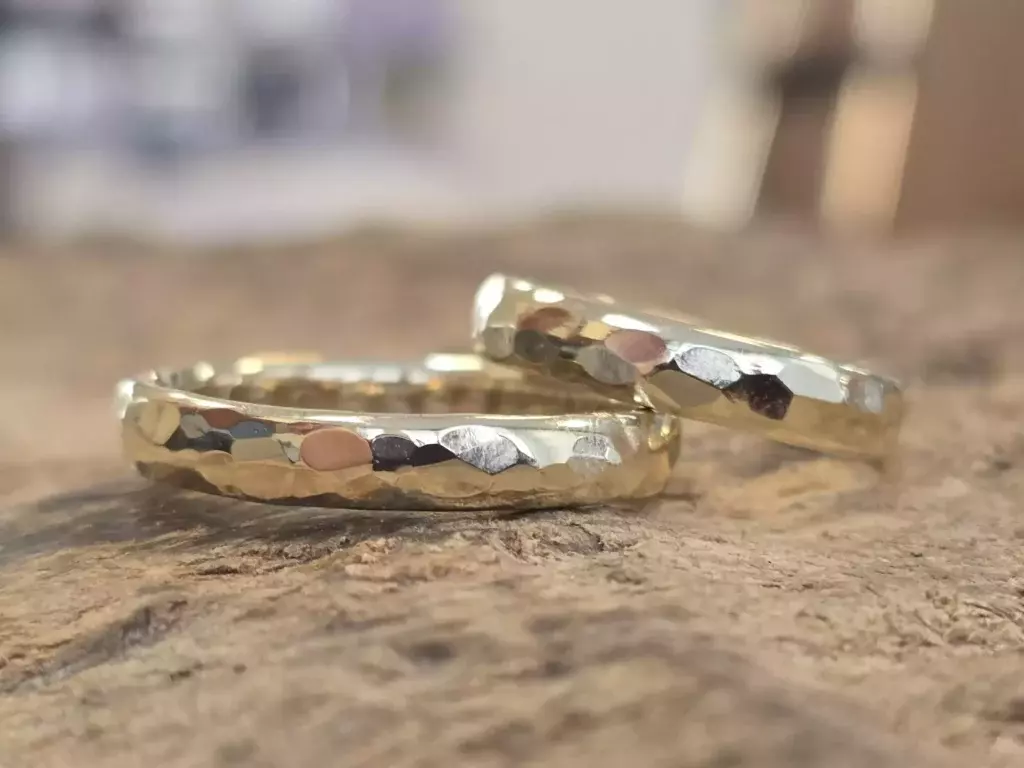 Selbst geschmiedete Trauringe aus Gelbgold mit gehämmerter Oberfläche aus dem Trauringkurs bei Trolese