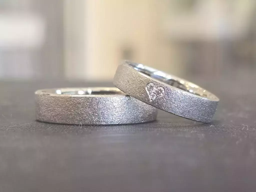 Trauringe selber schmieden – helle Trauringe mit matter Oberfläche und kleinem Diamant