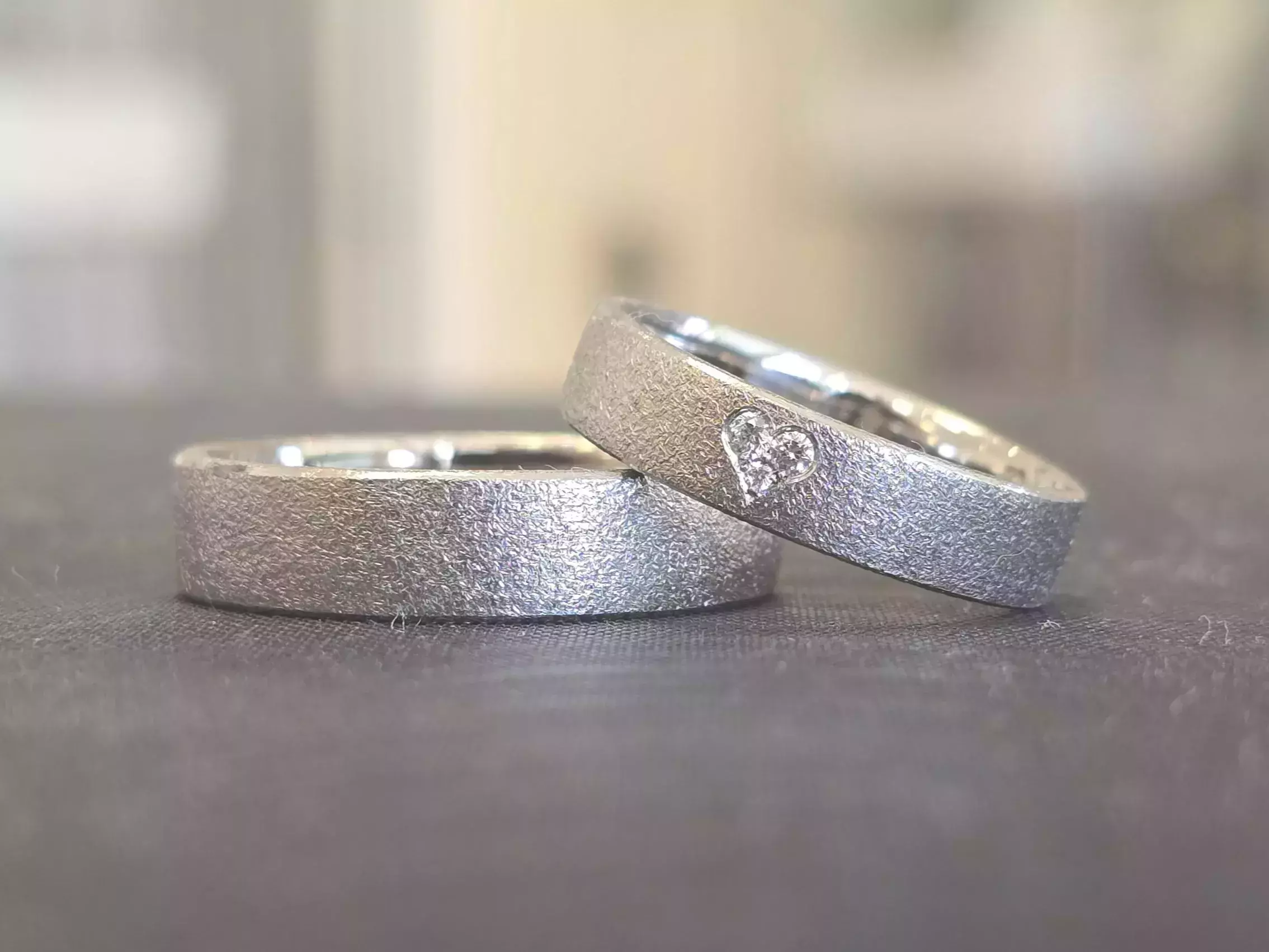 Trauringe selber schmieden – helle Trauringe mit matter Oberfläche und kleinem Diamant